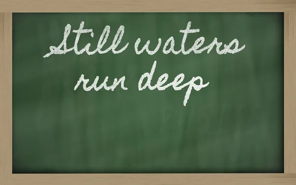 Uttryck - stilla vatten kör djupa - skrivit på en skola blackb — Stockfoto