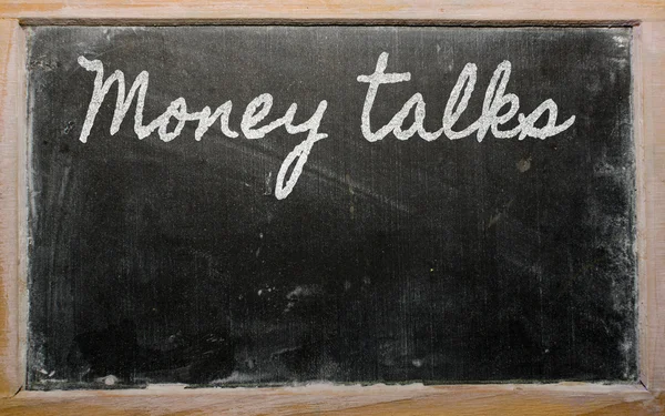 Выражение - Деньги говорят - написано на школьной доске с — стоковое фото