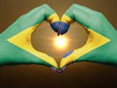 Heart and love gesture by hands colored in brazil flag during be