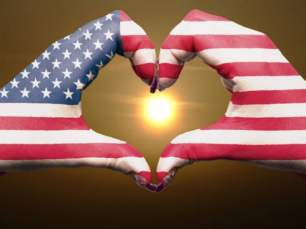 Szív és a szeretet gesztusa, kezében színes usa zászló alatt gyönyörû — Stock Fotó