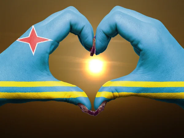 Corazón y gesto de amor con las manos coloreadas en la bandera de Aruba durante bea — Foto de Stock
