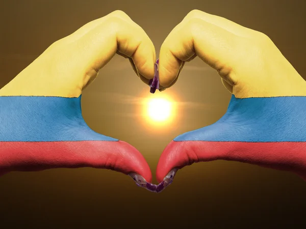 Жест любви и сердца руками, раскрашенными в флаг Колумбии во время — стоковое фото