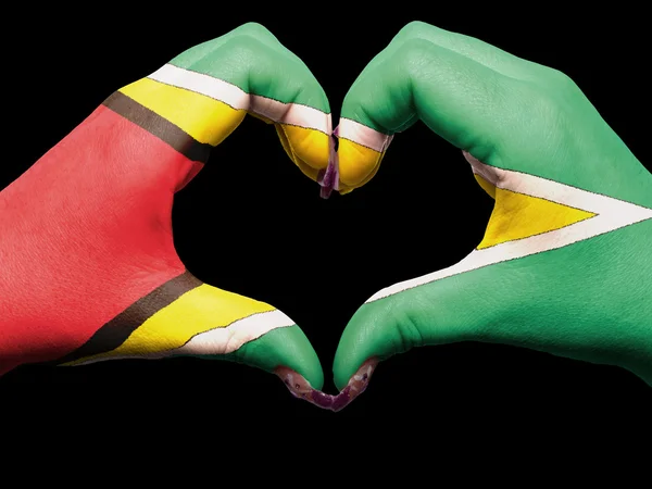 Жест любви и сердца руками, раскрашенными в флаг Гайаны для тури — стоковое фото