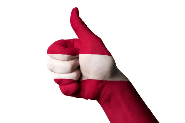 Lotyšsko státní vlajka s prstem gesto pro dokonalost a dosáhnout — Stock fotografie