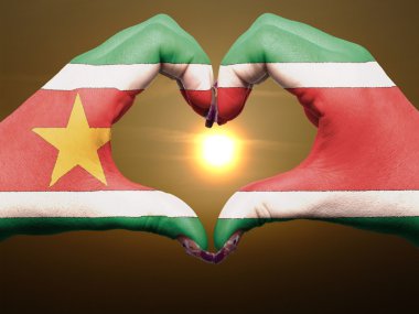 Heart and love gesture by hands colored in suriname flag during clipart