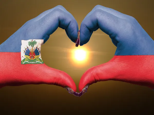 Hart en liefde gebaar door handen gekleurde in Haïti vlag tijdens bea — Stockfoto