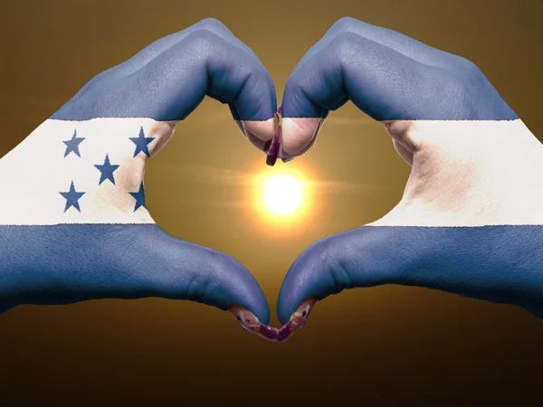 Coração e gesto de amor por mãos coloridas na bandeira honduras durante — Fotografia de Stock