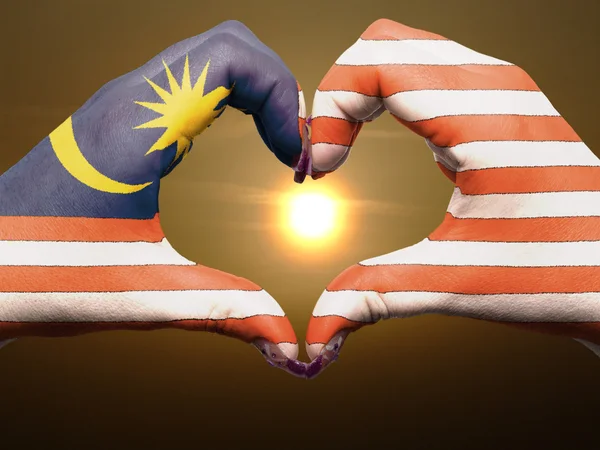 中にマレーシアの国旗の色の心と愛のジェスチャーの手で — ストック写真