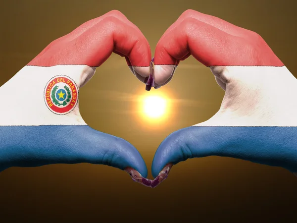 Geste de coeur et d'amour par les mains colorées dans le drapeau du paraguay pendant — Photo