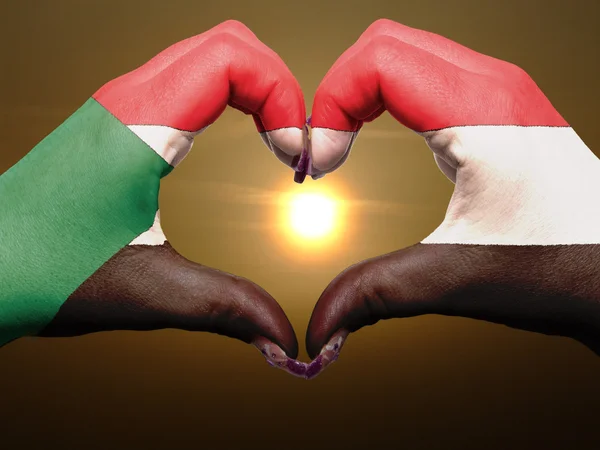 Heart and love gesture by hands colored in sudan flag during bea — Stock Photo, Image