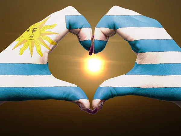 Жест любви и сердца руками, раскрашенными в уругвайский флаг во время b — стоковое фото