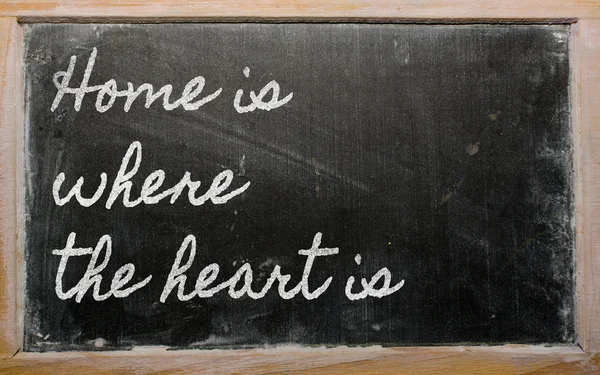 Expression - Home is where the heart is - written on a school b — Stock Photo, Image