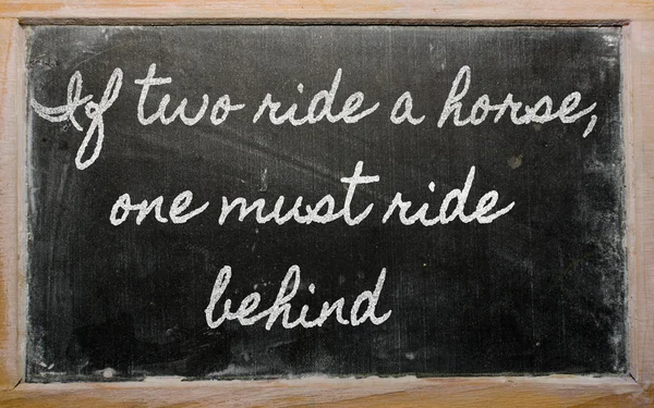 Ausdruck - wenn zwei auf einem Pferd reiten, muss man hinterher reiten - writte — Stockfoto