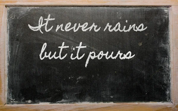 Expression - It never rains but it pours - written on a school — Stock Photo, Image