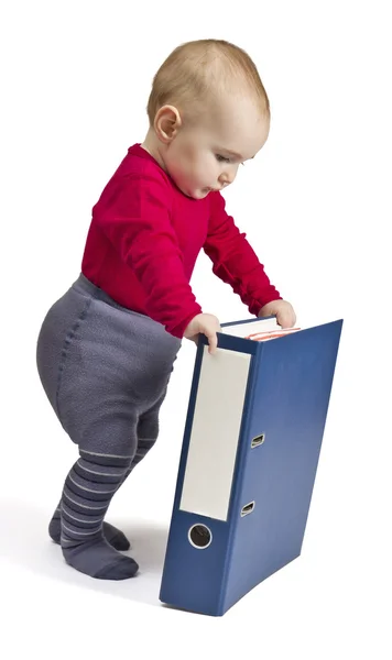 Niño pequeño de pie junto a aglutinante de anillo azul — Foto de Stock