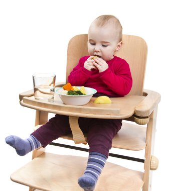 Young child eating in high chair clipart