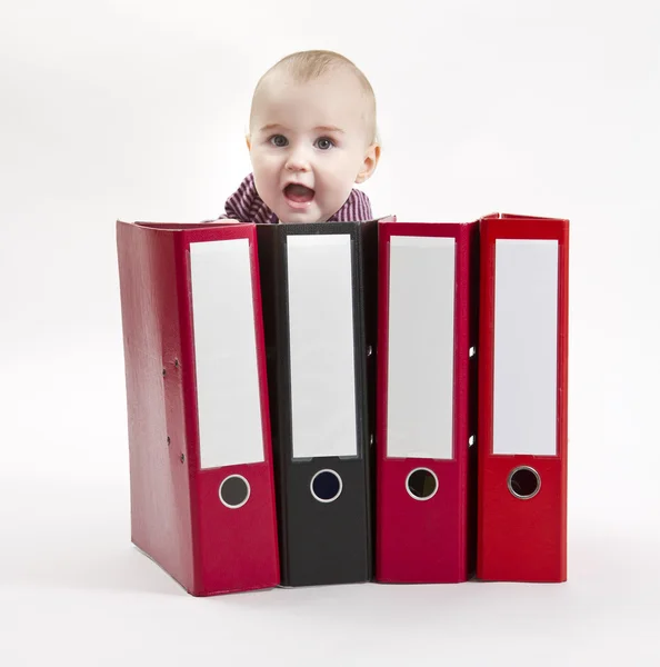 Young child hiding behind ring file — Stock Photo, Image