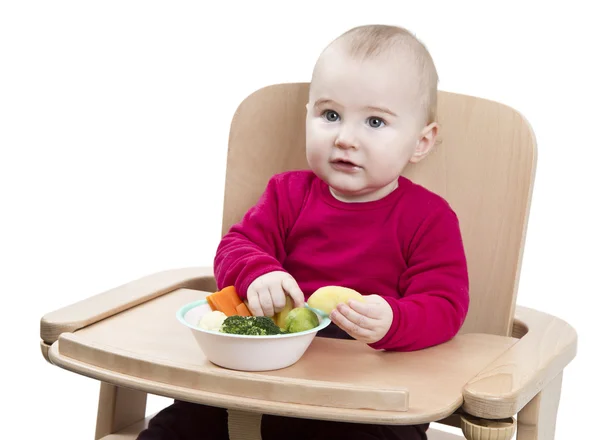 Jong kind eten in hoge stoel — Stockfoto