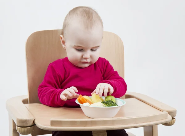 Niño pequeño comiendo en silla alta — Foto de Stock