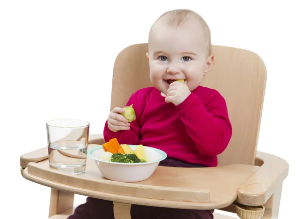 Young child eating in high chair — Stock Photo, Image