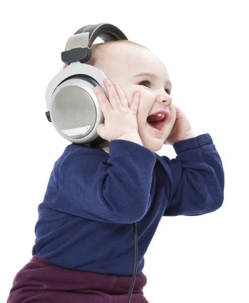 Young laughing child with ear-phones listening to music — Stock Photo, Image