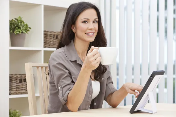 Γυναίκα με τη χρήση υπολογιστή δισκίο στο σπίτι πίνει τσάι ή καφέ — Φωτογραφία Αρχείου