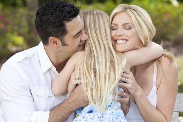 Meisje kind knuffelen gelukkige ouders in park of tuin — Stockfoto
