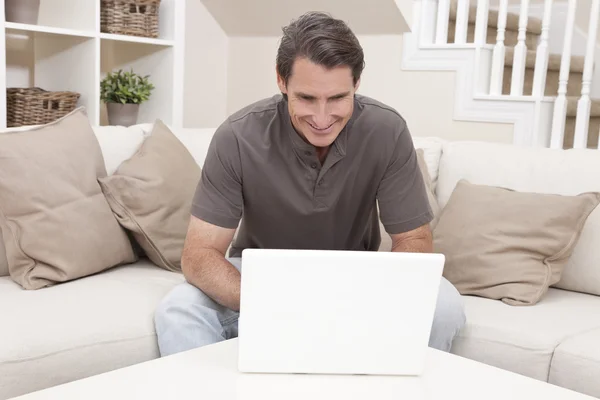 Gelukkig man thuis laptopcomputer gebruikt — Stockfoto