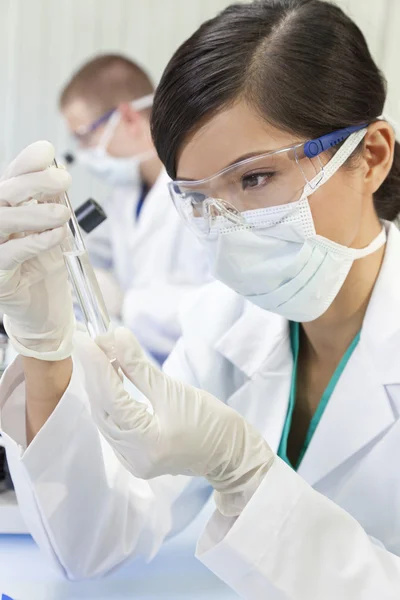 Chinesische Wissenschaftlerin mit Reagenzglas im Labor — Stockfoto