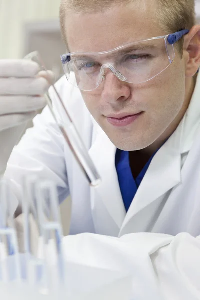 Ученый мужского пола или врач с пробиркой в лаборатории — стоковое фото
