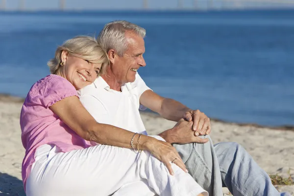 Feliz romântico casal sênior sentado juntos na praia — Fotografia de Stock