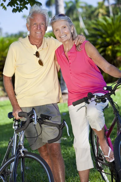 Felice coppia di anziani in bicicletta in un parco — Foto Stock