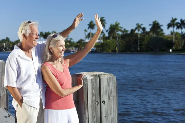 Glückliches Senioren-Paar winkt draußen bei Sonnenschein am Meer — Stockfoto