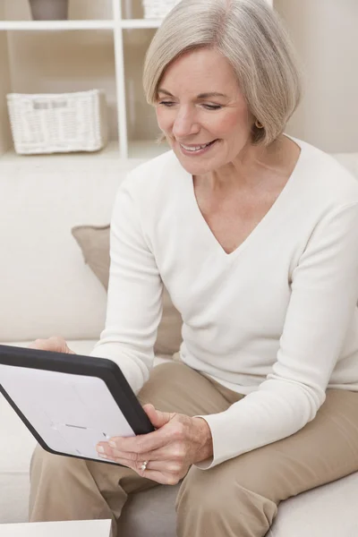 Привлекательная пожилая женщина с планшетным компьютером — стоковое фото
