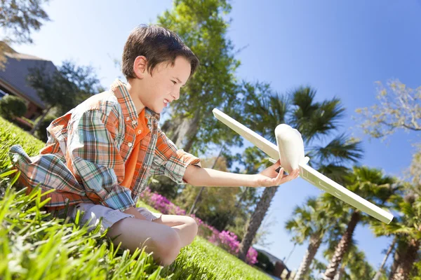 Młody chłopiec bawi się modelu samolotu poza — Zdjęcie stockowe
