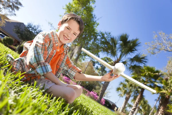 Chico joven jugando con el modelo aeroplano exterior — Foto de Stock