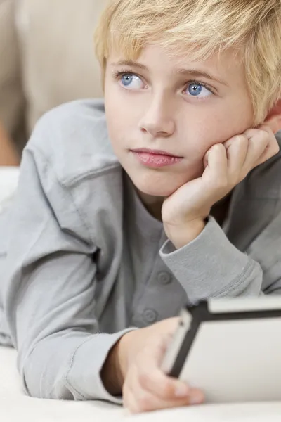 Sarı saçlı mavi gözlü erkek çocuk tablet bilgisayar kullanma — Stok fotoğraf