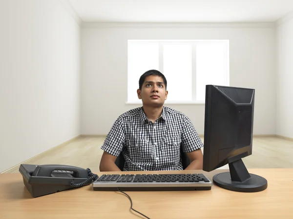 Man seated in isolated room — Stock Photo, Image