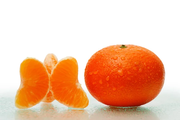 Verse oranje vruchten met segmenten en waterdruppels. — Stockfoto