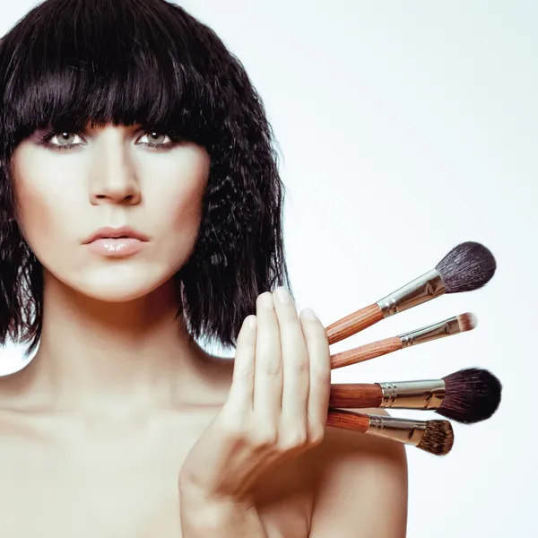 Beautiful woman with makeup brushes — Stock Photo, Image