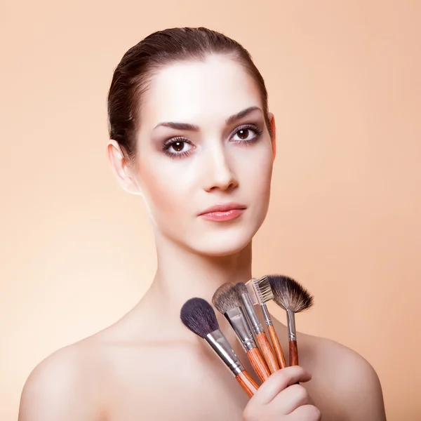 Portrait of beautiful woman with makeup brushes — Stock Photo, Image