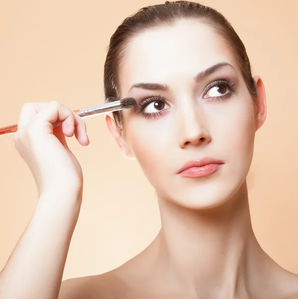 Close-up portrait of young beautiful woman with brush for make-u — Stock Photo, Image