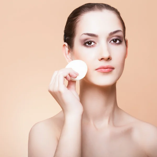 Donna che pulisce il viso con spugna di cotone — Foto Stock