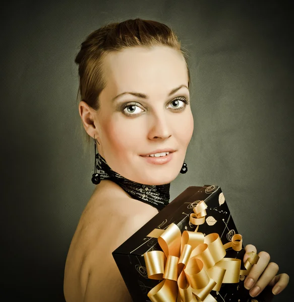 Sexy girl holding a gift in magic packing — Stock Photo, Image