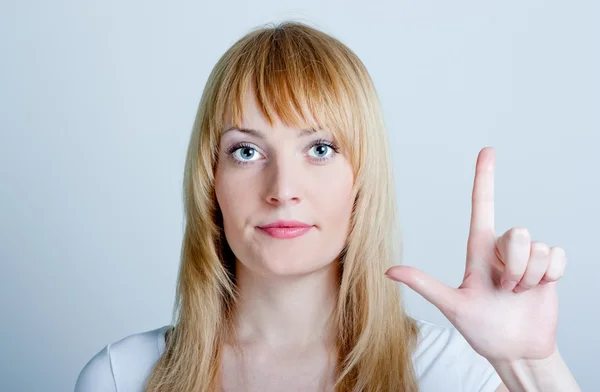 Pretty woman holding up one finger — Stock Photo, Image