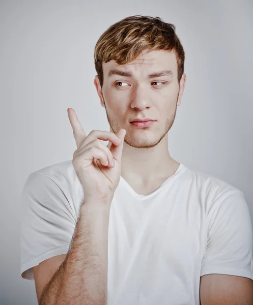 Portrait of young man pointing with finger — Stock Photo, Image