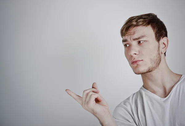Porträt eines jungen Mannes, der mit dem Finger zeigt — Stockfoto