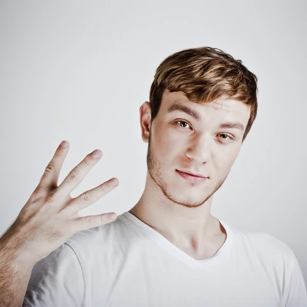 stock image Young man holding up two fingers