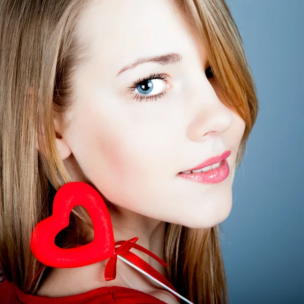 Linda jovem loira segurando um coração vermelho — Fotografia de Stock