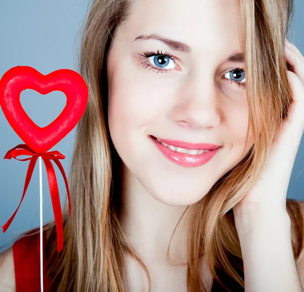 Beautiful girl blonde with red heart in hand — Stock Photo, Image
